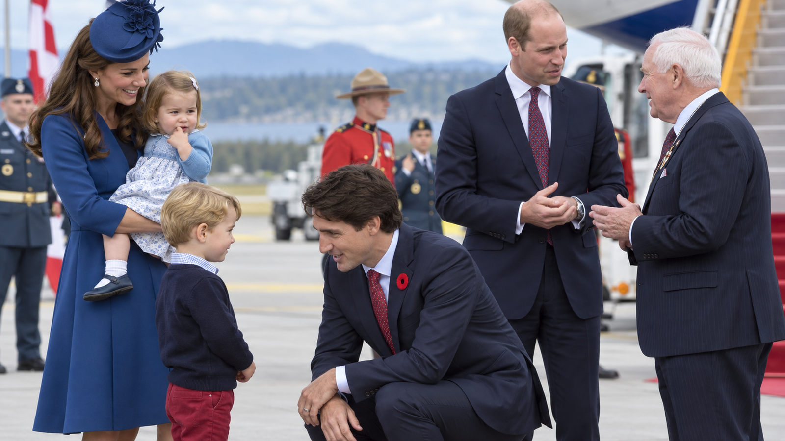 Canadian Prime Minister Justin Trudeau, center, kneels to talk to Prince George as his father, Prince William, The Duke of Cambridge, speaks with Governor General David Johnston, right, and Kate, The Duchess of Cambridge, holds their daughter Princess Charlotte upon arrival in Victoria, British Columbia, Saturday, Sept. 24, 2016.